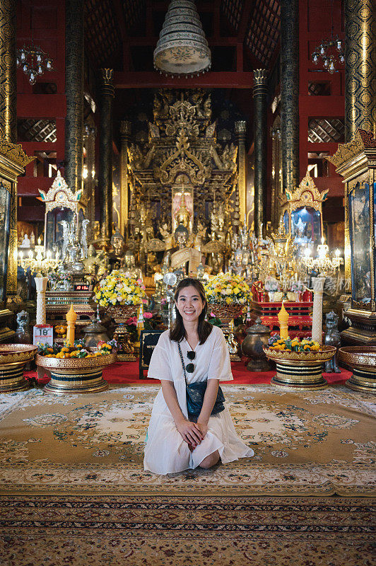 年轻的中年亚洲人在泰国北部清迈著名的旅游景点Phra Aram Luang寺祈祷